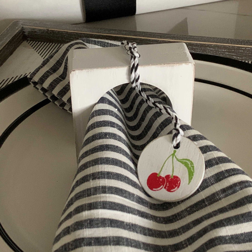 Colorful cherry wood napkin ring styled with a cloth napkin.