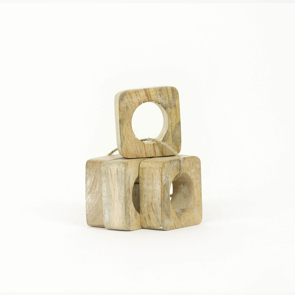 Set of four natural mango wood square napkin rings arranged on a table.