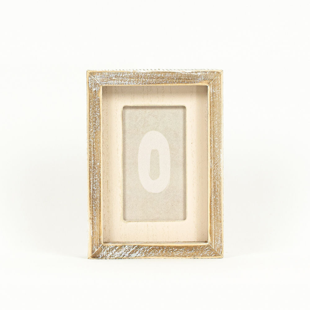 Wood framed sign featuring w circle styled on a shelf or console table.