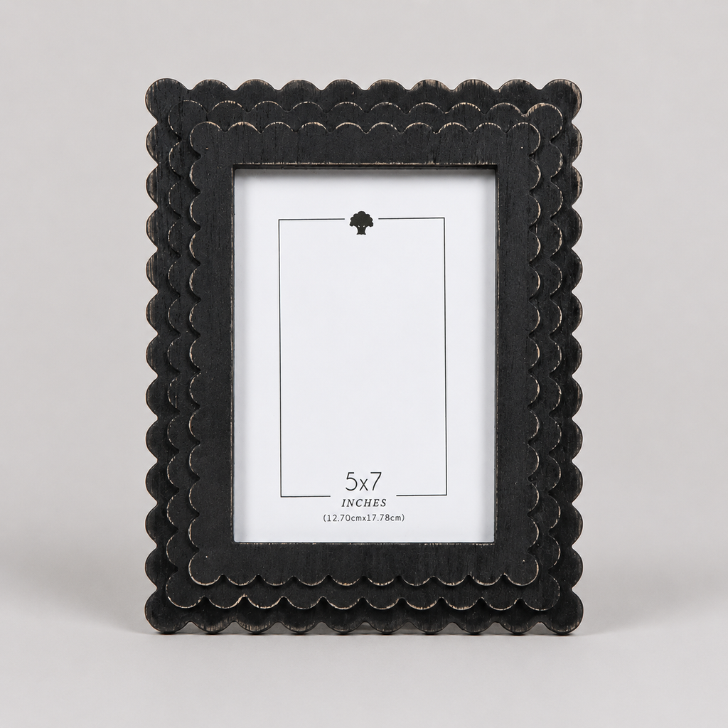 Black scalloped wood picture frame holding a 5x7 photo
