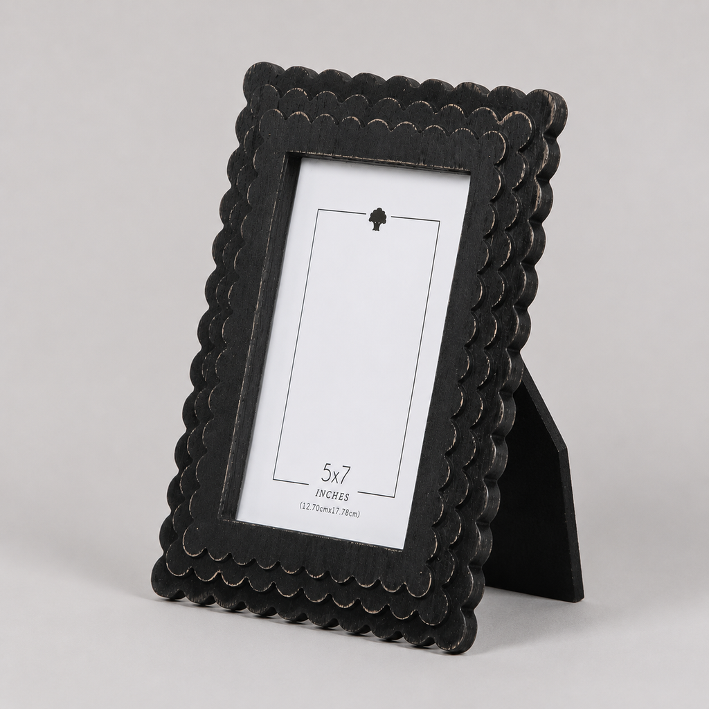 Black scalloped wood picture frame holding a 5x7 photo