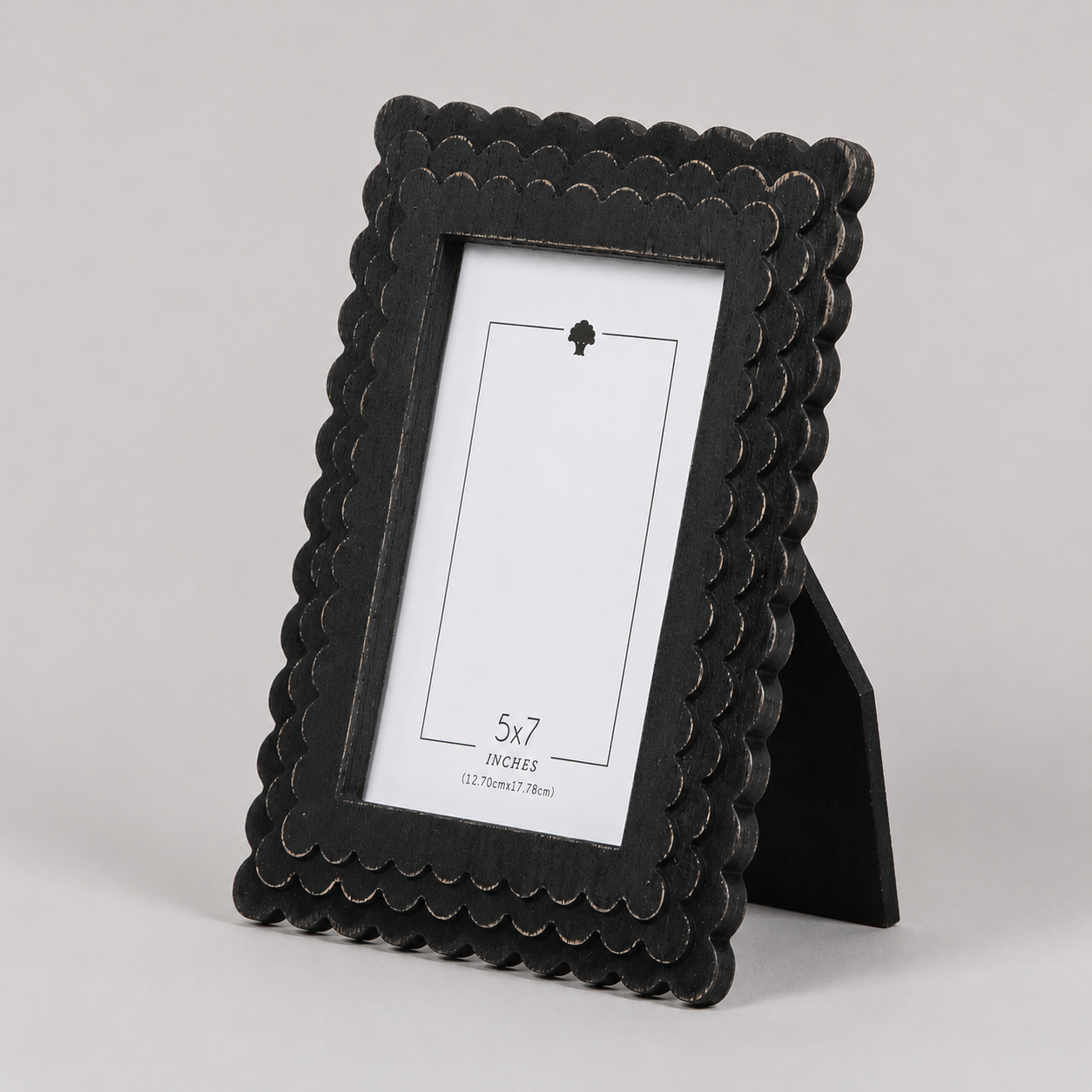 Black scalloped wood picture frame holding a 5x7 photo