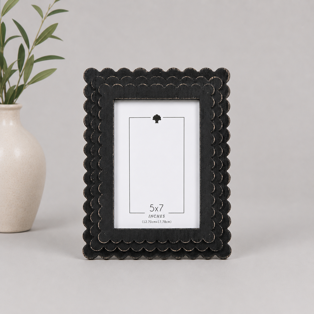 Black scalloped wood picture frame holding a 5x7 photo, side detail view