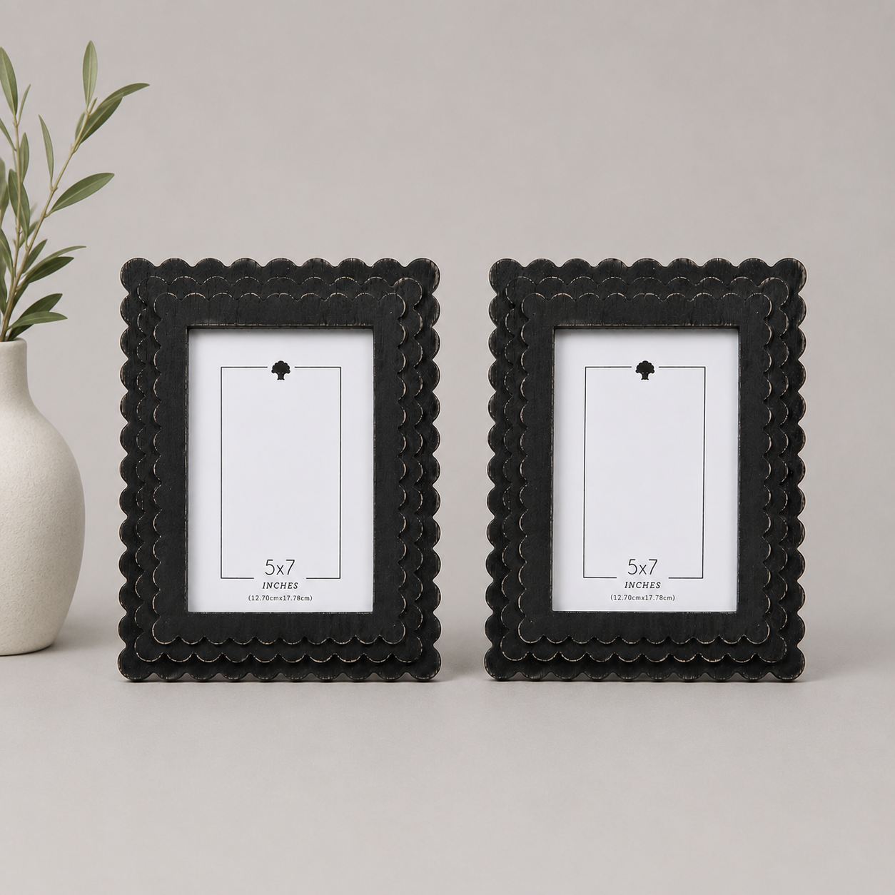 Black scalloped wood picture frame holding a 5x7 photo, back easel view