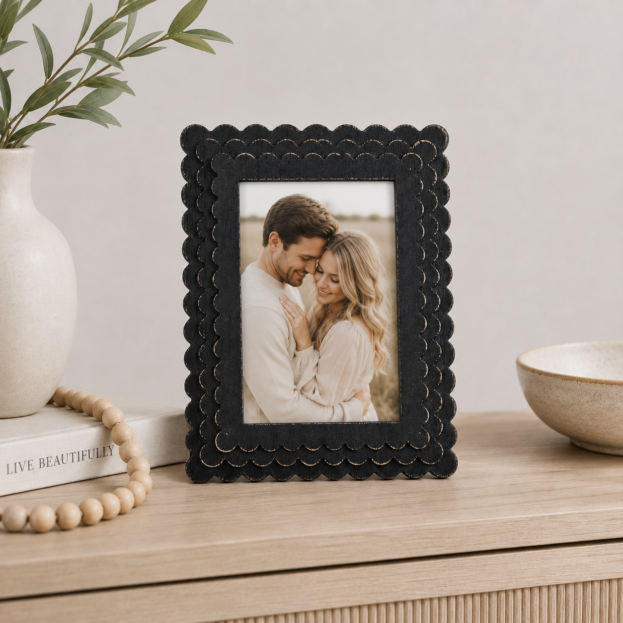 Black scalloped wood picture frame holding a 5x7 photo, front view