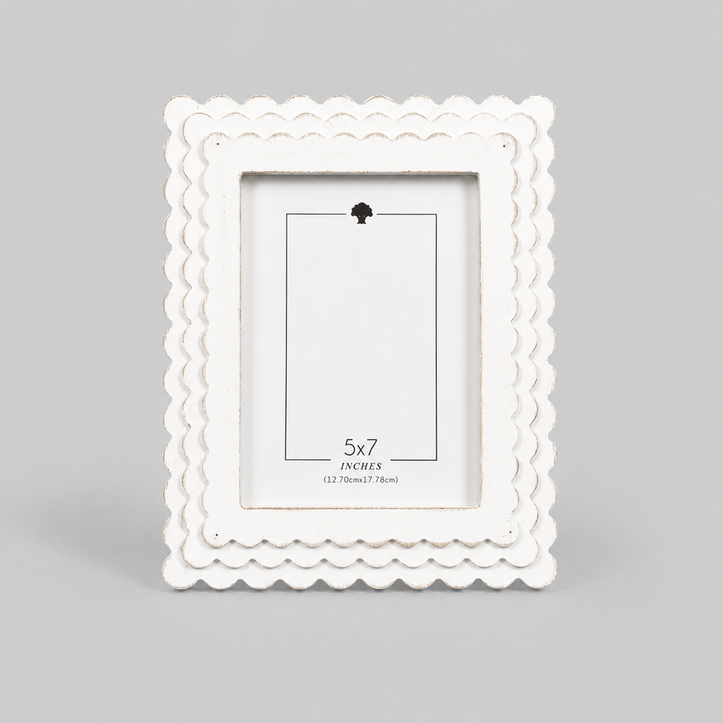 White scalloped wood picture frame holding a 5x7 photo