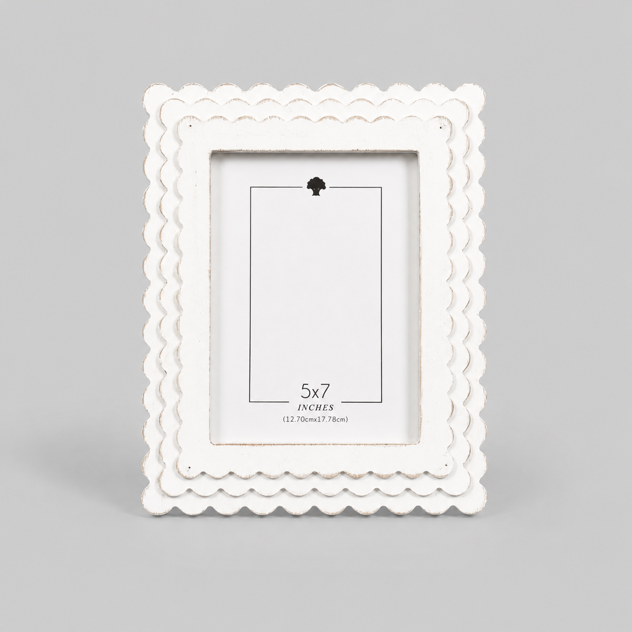 White scalloped wood picture frame holding a 5x7 photo