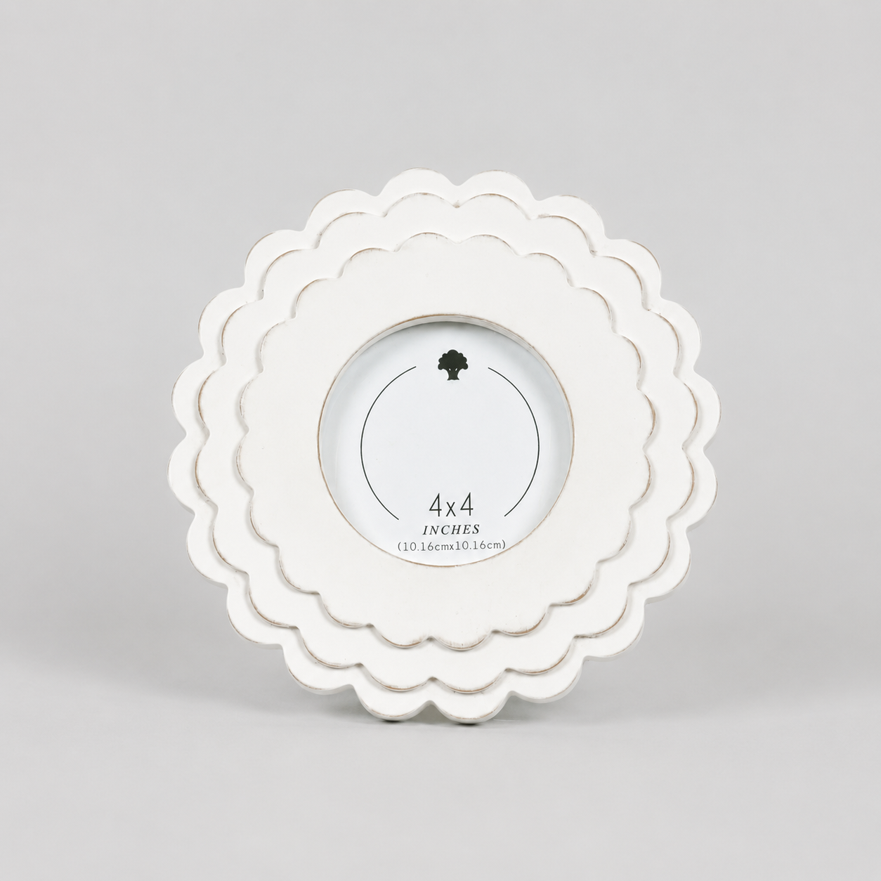 White round scalloped wood picture frame holding a 4x4 photo