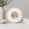White round scalloped wood picture frame holding a 4x4 photo, side detail view