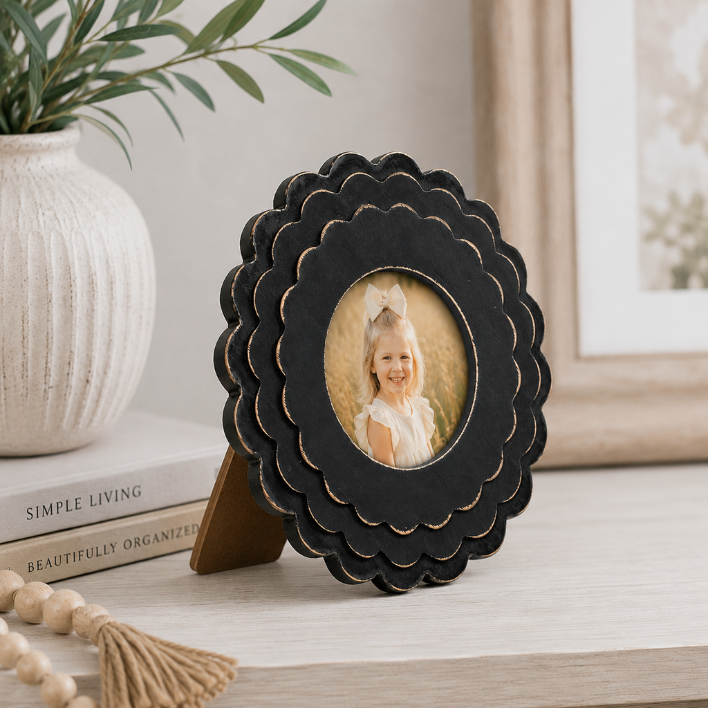 Black round scalloped wood picture frame holding a 4x4 photo, angled view