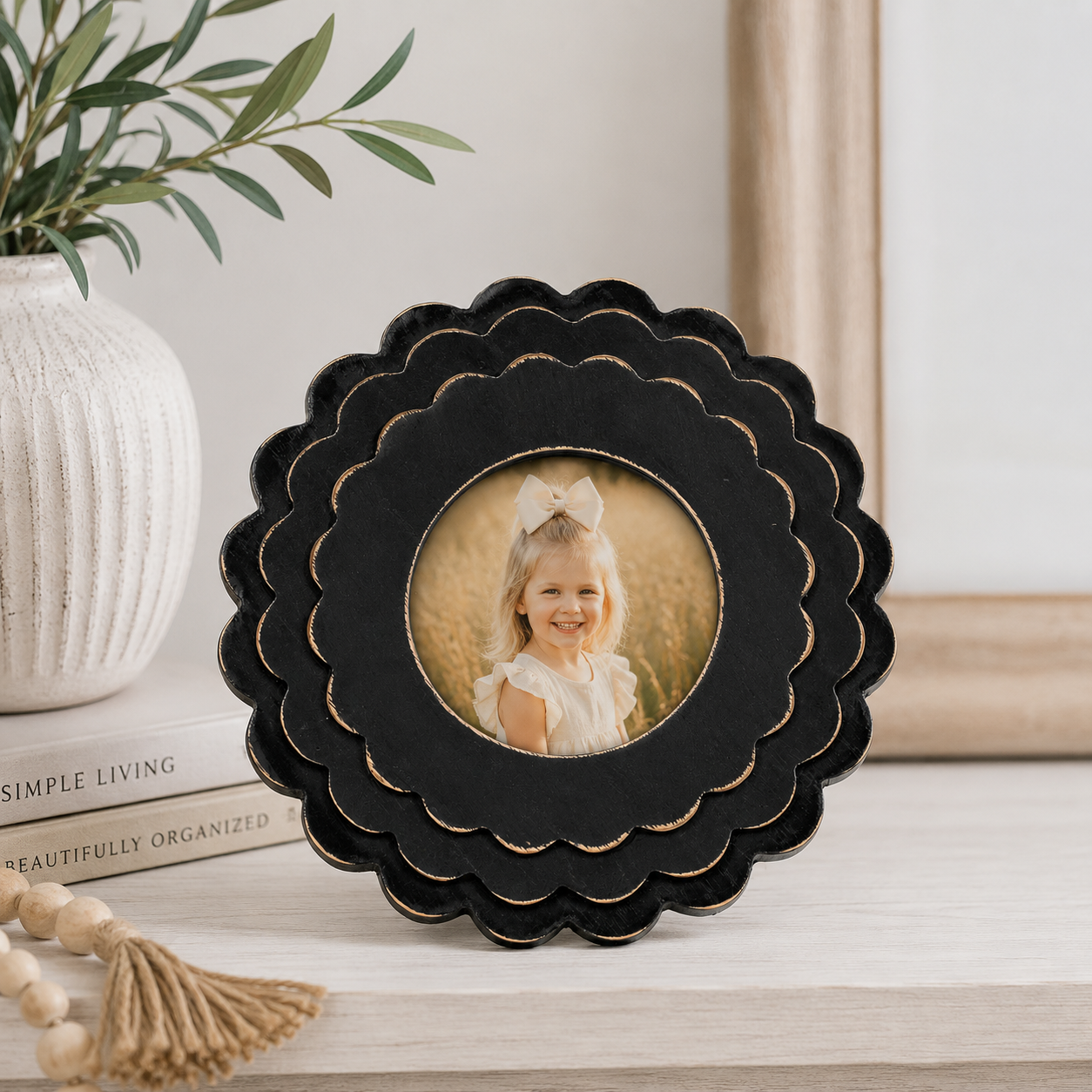 Black round scalloped wood picture frame holding a 4x4 photo, front view