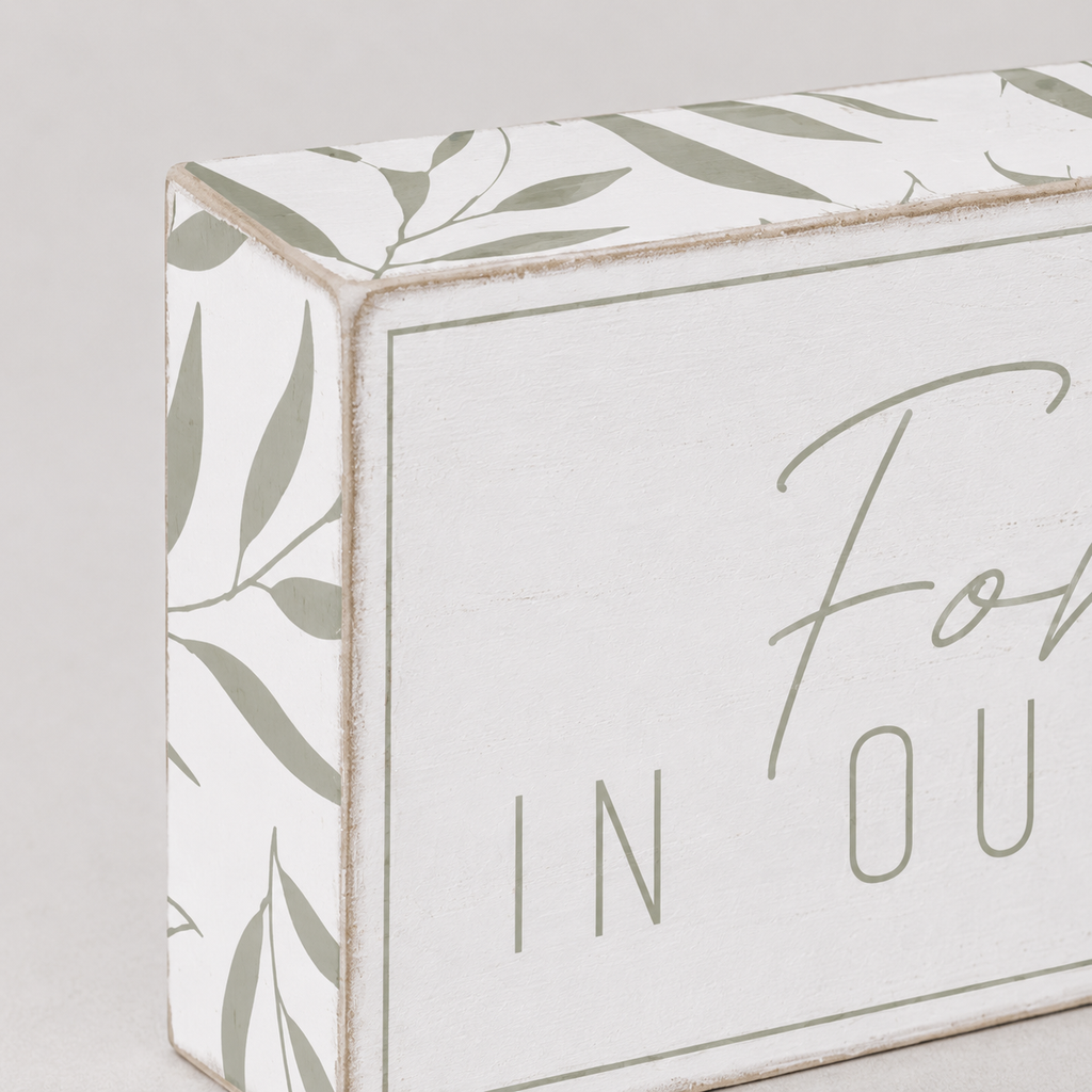 Wood framed sign featuring forever in our hearts styled on a shelf or console table.